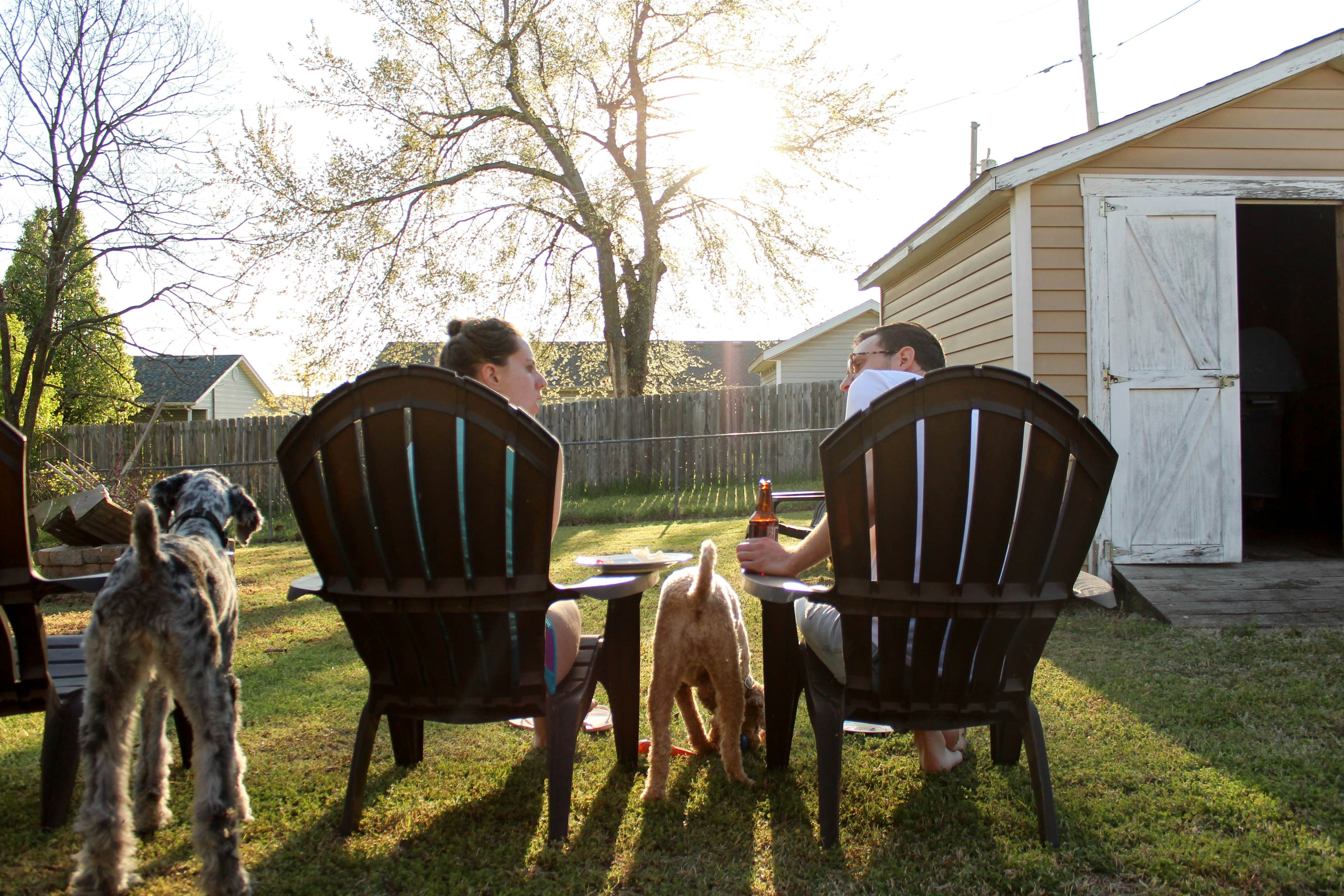 Family enjoying a clean backyard with their dogs at sunset